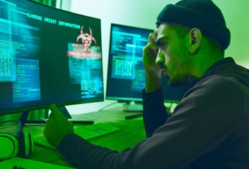 Person sitting in front of computer monitors