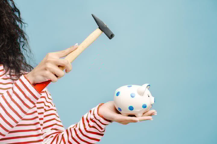 woman breaking open her piggy bank